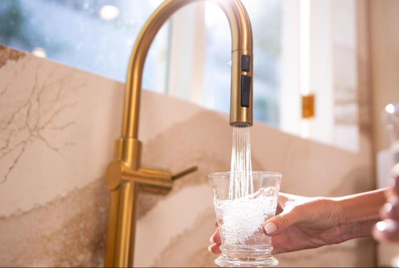 Kitchen faucet running water into a sink