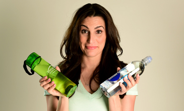 woman holding two different bottles of water in her hands