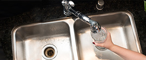 woman pouring water into a glass