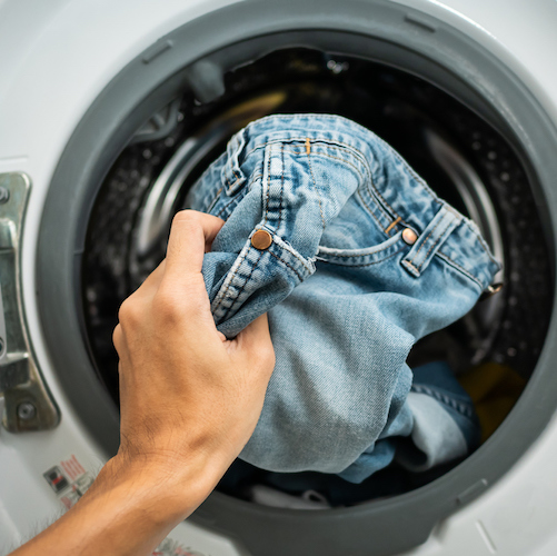 a landry being pulled out from a washing machine