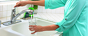 woman fills a glass with water