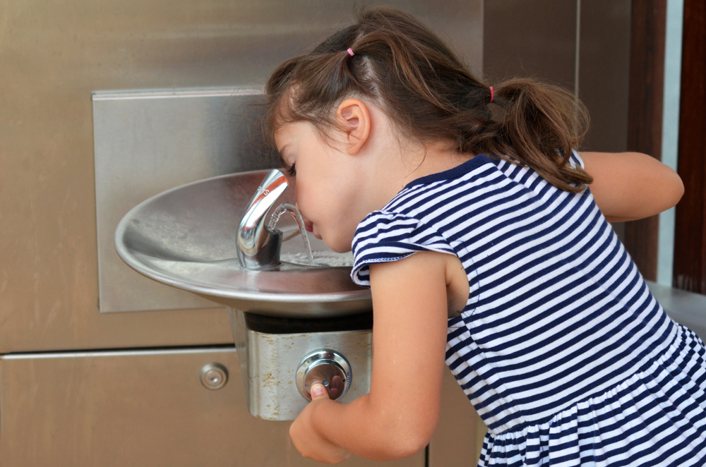 kid drinking water from fountain