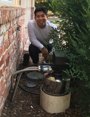Eric kneeling down next to his installed water tank